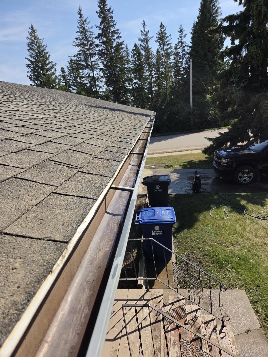 Same gutter after cleaning, with pressure washer on the drive
