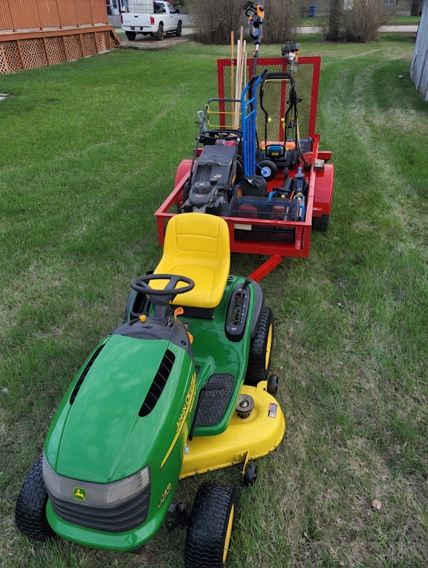 John Deere riding mower and loaded red trailer ready for a job